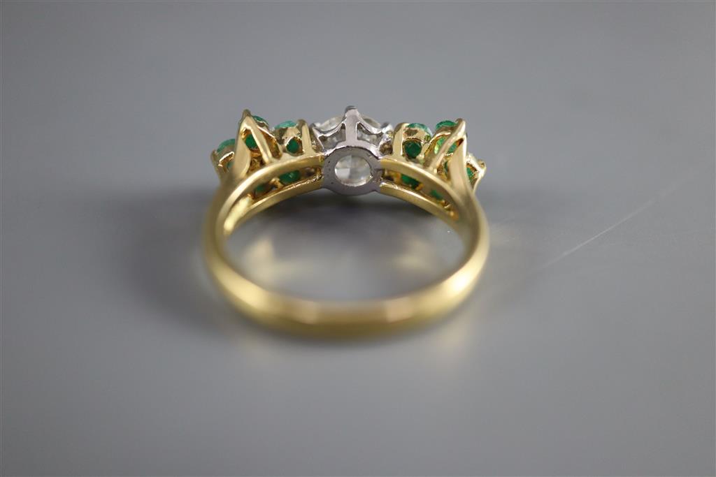 A modern 18k emerald and diamond set dress ring,